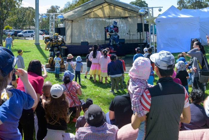 A crowd of people watching a performer on the stage. 