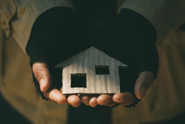 person holding a cut out of a house