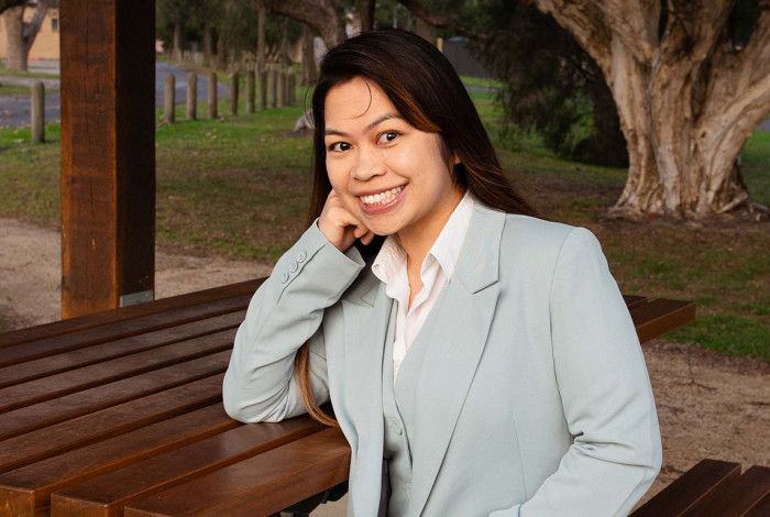 Councillor Melinda Yim sitting at a park bench