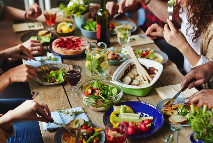 Food on a dinning table with people eating