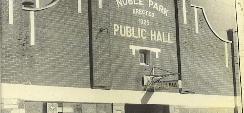 An ornate brick building with a sign reading Noble Park Public Hall erected 1825.