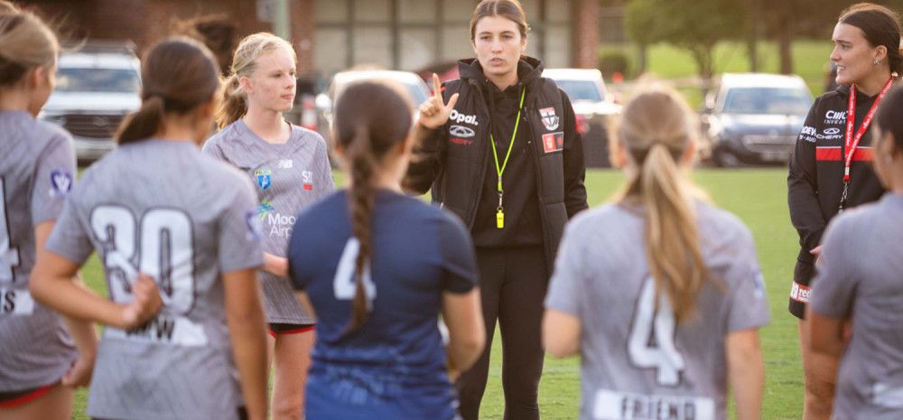 Coach and players on a sporting ground