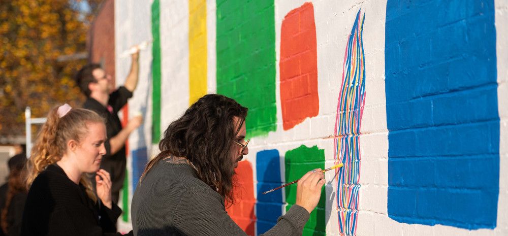 People painting a mural on a wall