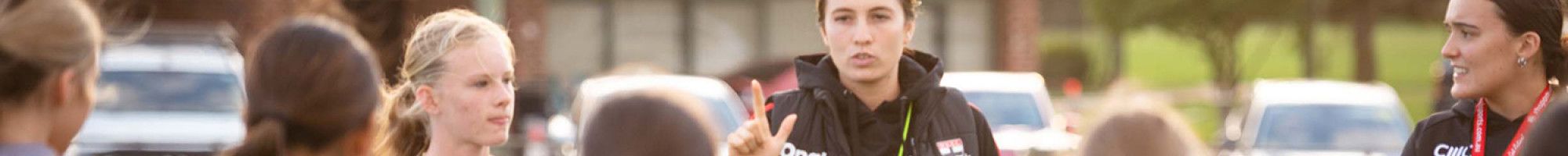 Coach and players on a sporting ground