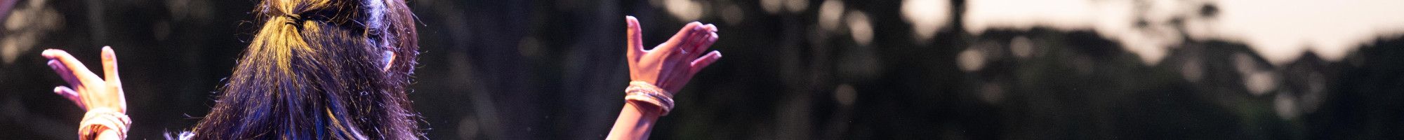 A woman dances on stage in front of a large crowd