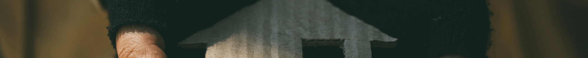 person holding a cut out of a house