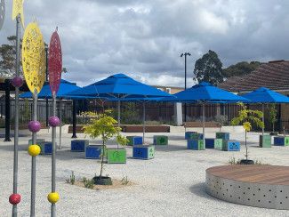 Landscaped area with tables and umbrellas.